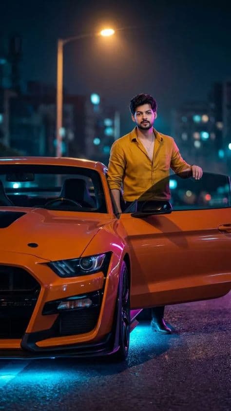 A modified vivid orange Ford Mustang Shelby GT500 parked under city streetlights with sleek road reflections.