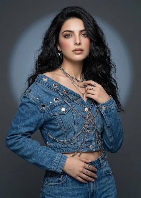 A chic model styled in tailored denim and bold silver hardware under crisp studio lighting.