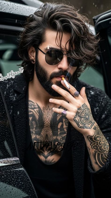 Bearded man in dark streetwear leaning beside a black car in the rain, holding a cigarette and wearing aviator sunglasses in a moody editorial portrait.