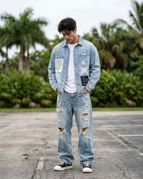 Full-body outdoor portrait of a young man in oversized denim jacket and distressed jeans